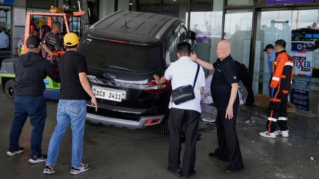 マニラの<ruby ><rb><span class="jlpt-n4" word="空港">空港</span></rb><rt>くうこう</rt></ruby>で<ruby ><rb><span class="jlpt-n5" word="車">車</span></rb><rt>くるま</rt></ruby>が<ruby ><rb><span class="jlpt-n5" word="人">人</span></rb><rt>ひと</rt></ruby>に<span class="jlpt-n2" word="ぶつかる">ぶつかる</span>